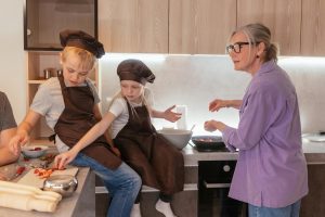 elderly woman cooking with two grandchildren